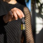 Frau hält Swiss FX CBD Öl 15% Vollspektrum Flasche in den Fingern